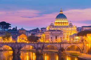 Night view of old roman Bridge of Hadrian and St. Peter's cathedral in Vatican City, Rome, Italy.